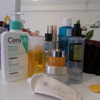 A range of skincare products in bottles and jars, collected on a shelf.