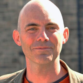 A headshot of James Tulloch, Learning and Evaluation Manager, smiling.